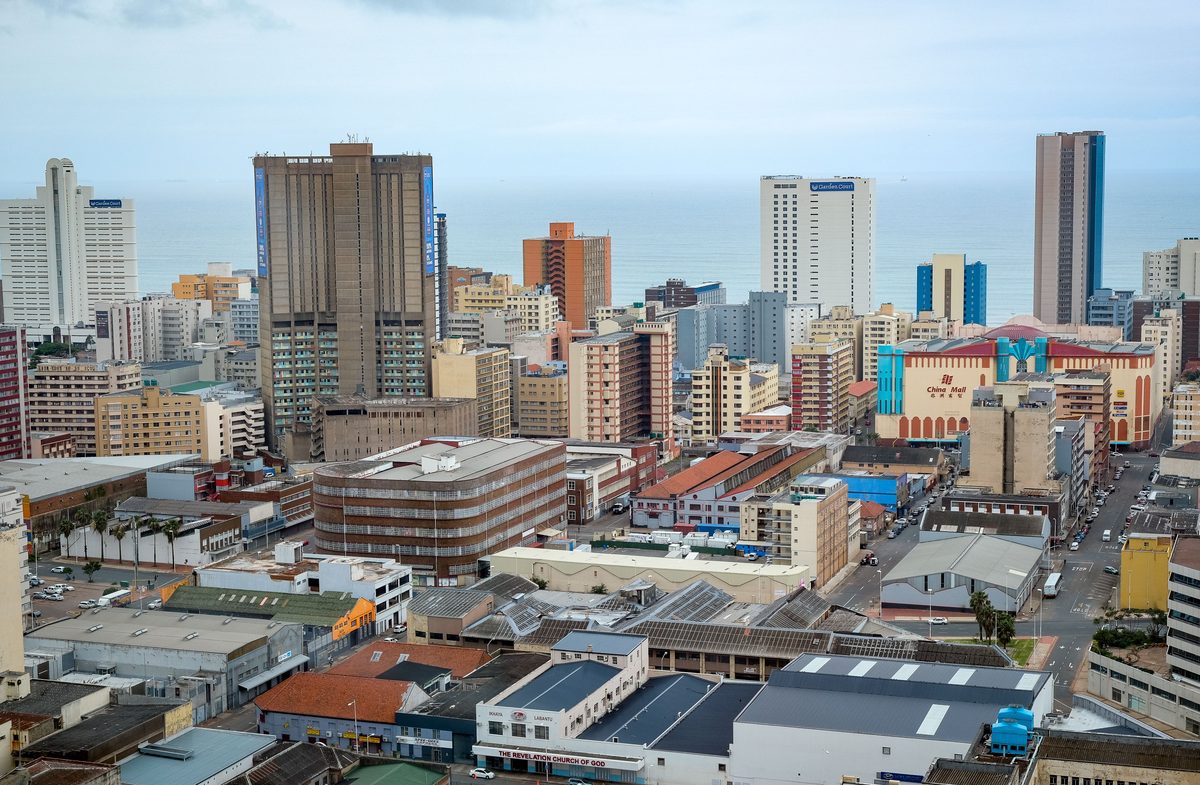 Durban's city centre from above, high-rise blocks and older warehouses running down to the Indian Ocean, with the China Mall and beachfront hotels among them