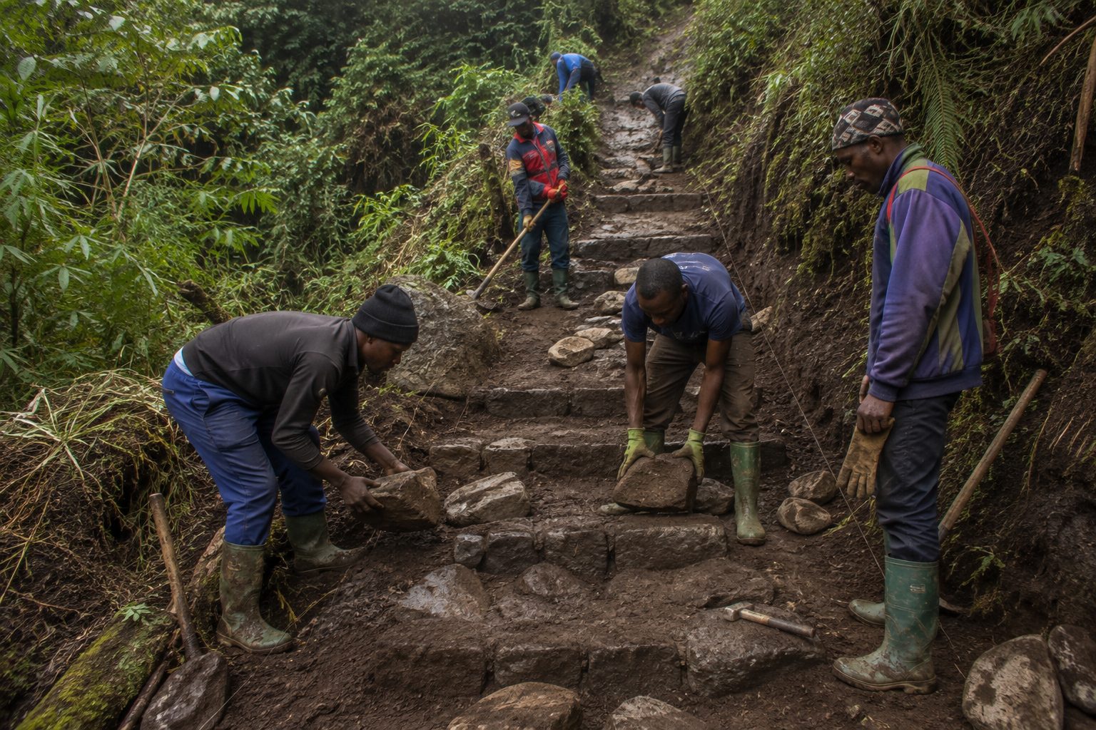 Villagers and guides working together on a repaired section of mountain trail